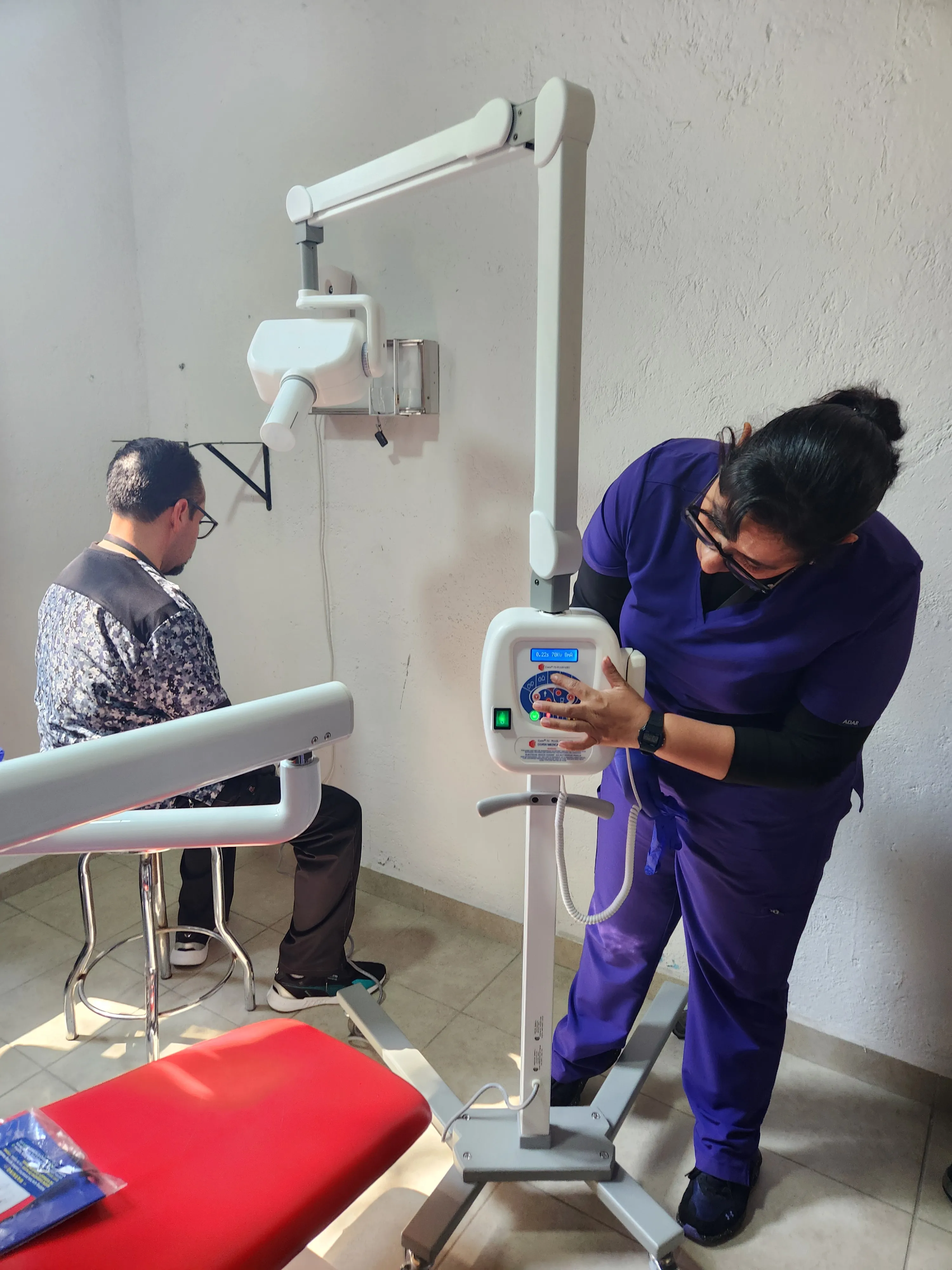Odontóloga revisando equipo Corix antes de realizar una radiografía dental, mostrando cómo mejorar la precisión diagnóstica 
               con rayos X panorámicos.